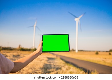 Green Screen Tablet On The Windmills Background. Chroma Key. Windmills Green Energy