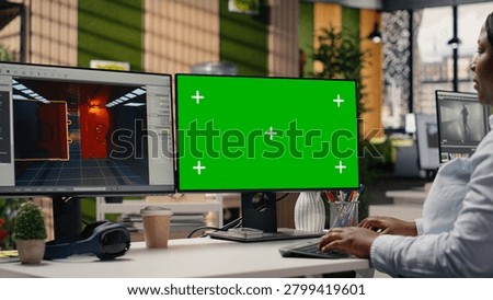 Green screen and video game software on dual monitors at the office, developer working with tools and assets to build a futuristic virtual world. Engineer developing gameplay mechanics.