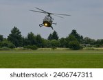 green search and rescue helicopter landing on the grass late evening