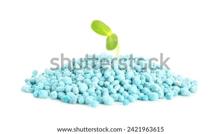 Green seedling growing from pile of blue granular fertilizer on white background [[stock_photo]] © 