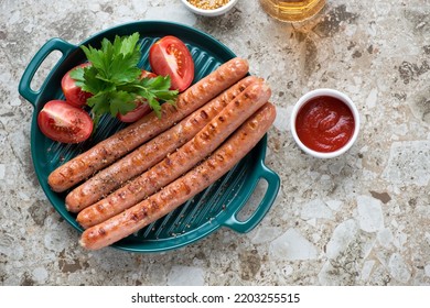 Green Serving Tray With Barbecued Sausages, Tomatoes, Parsley And Dips, Above View On A Light-brown Granite Background, Horizontal Shot