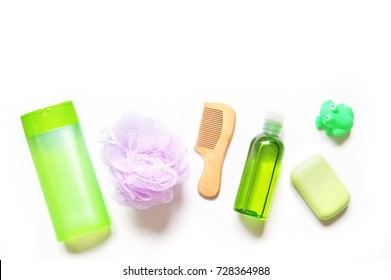 Green Shampoo Bottle, Purple Sponge Puff, Wooden Comb, Essential Oil, Baby Soap And Toy Frog. Flat Lay Bathroom Items. Organic Cosmetics