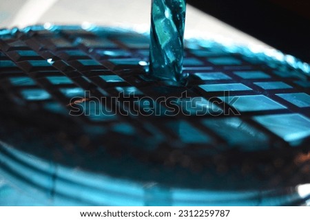 Green, shinny, glass, water bottle with straw with glowing light reflection and shadows, texture and geometric designs.
