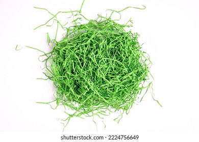 Green shredded paper packaging material on white background. Paper filler for gift box, stuffing and shipping. 
