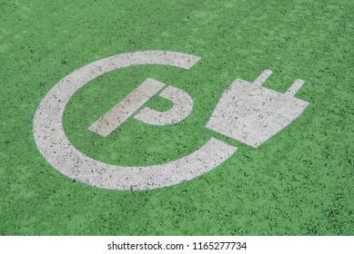 Green Sign For Charging Place For Electric Cars In A Parking Lot On Asphalt