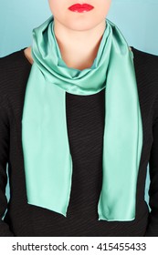 Green Silk Scarf Around Her Neck Isolated On Blue Background. Female Accessory.