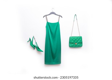 Vestido de patinaje verde cerca de colgar con bolso de mano, zapatos 