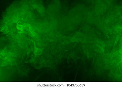 Green smoke texture on a black background. Texture and abstract art