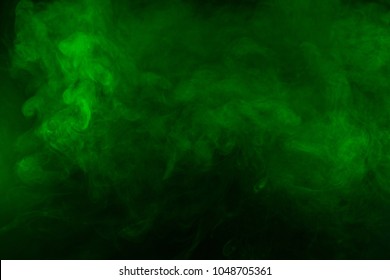 Green smoke texture on a black background. Texture and abstract art