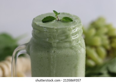 Green Smoothie Made Of Frozen Green Grapes, Fresh Baby Spinach, Bananas And Almond Milk. Served In Mason Jar. Shot On White Background.