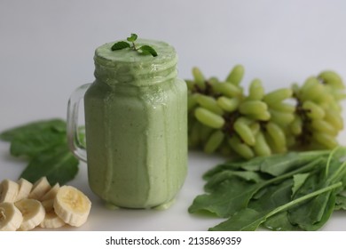 Green Smoothie Made Of Frozen Green Grapes, Fresh Baby Spinach, Bananas And Almond Milk. Served In Mason Jar. Shot On White Background.