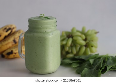 Green Smoothie Made Of Frozen Green Grapes, Fresh Baby Spinach, Bananas And Almond Milk. Served In Mason Jar. Shot On White Background.