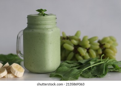 Green Smoothie Made Of Frozen Green Grapes, Fresh Baby Spinach, Bananas And Almond Milk. Served In Mason Jar. Shot On White Background.