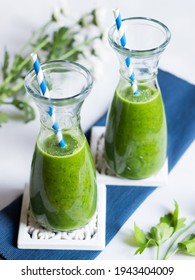 Green smoothie in two carafes. Made of kale, green apple, pineapple and parsley. Fit and healthy diet drink.