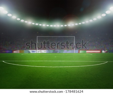 Green soccer field, bright spotlights, illuminated stadium 