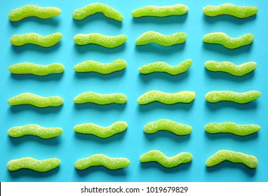 Green Sour Worm Candy On Bright Blue Background