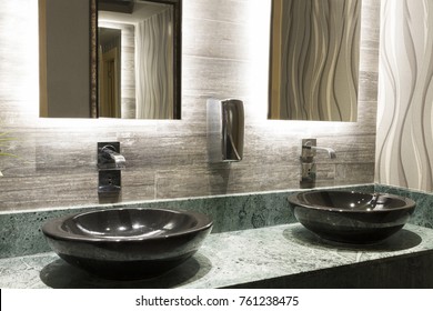 Green Special Design Marble Counter, Black Top Counter Washbasin, Beautiful Pink Flower, Chrome Tap, Metal Soap Dispenser And Beige Textured Wall Tiles At Commercial Public Bathroom In Office Building