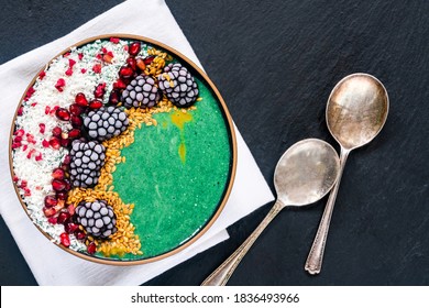 Green Spirulina Smoothie Bowl With Fruit And Linseed - Healthy Superfood Breakfast Idea. Overhead View