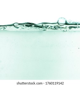 Green splashing cosmetic moisturizer, micellar water, toner, or emulsion abstract background. Transpatent texture with bubbles