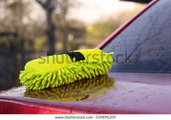 Green sponge for\
the washing cars on red\
car