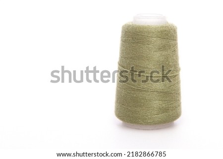Green spool of thread isolated on white background. Skein of woolen threads. Yarn for knitting. Materials for sewing machine. Coil.