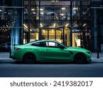 Green sports car parked in front of a modern building, evening side shot of car