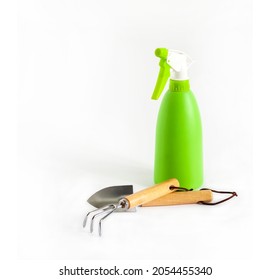 Green Spray Bottle And Garden Tools On White Background. Plant Care Concept