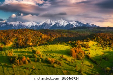 Green spring meadow with snowy mountains in the backgroound and colorful sky. High Tatras NP, Slovakia. Vysoke tatry. Osturna village - Shutterstock ID 1866468724