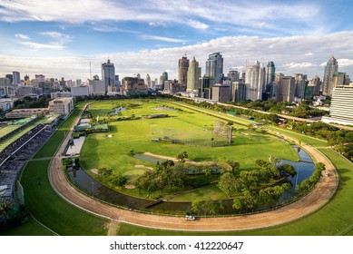 Green Stadium Field Of Horserunner In Center On Bangkok Cityscape Background