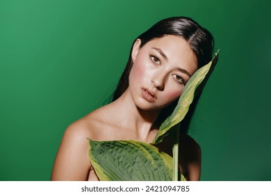 Green Summer Beauty: Young Caucasian Woman with Attractive Portrait and Fresh Makeup, Surrounded by Tropical Leaves in a Exotic Park