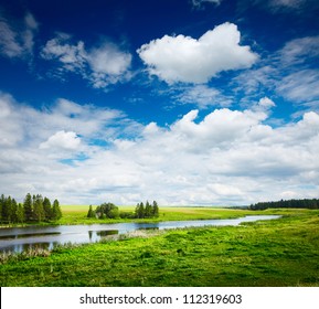 Green summer meadow and pond with blue cloudy sky - Powered by Shutterstock