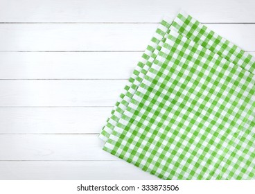 Green Tablecloth On Bleached Wooden Table. Napkin On White Wooden Table