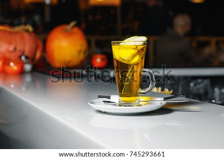 Green tea with apple slices in a glass cup on a white bar counter