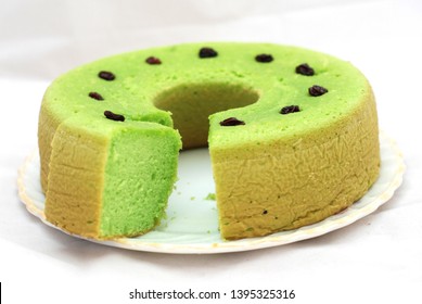 Green Tea Flavored Sponge Bread Light Green With Raisin Seeds Above It With A Plain White Background
