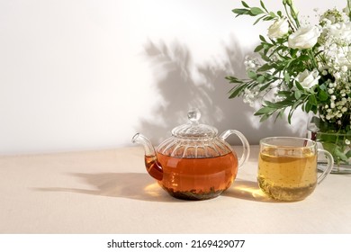 Green tea oolong in glass teapot on table. Hot tea is in the glass cup.Teapot and cup of tea with green tea on the table. Copy space.