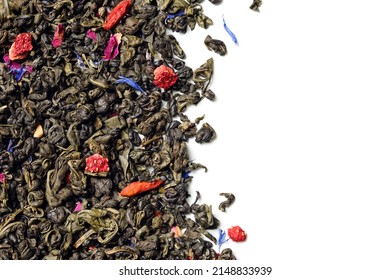 Green tea with strawberry, goji berries, knapweed petals and rose buds on white background. Top view. Close up. High resolution.