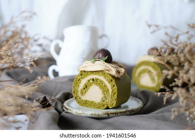 Green Tea Swiss Roll Cake With Chestnut Cream Filling Set On Cafe Table.