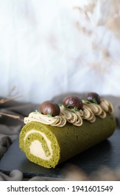 Green Tea Swiss Roll Cake With Chestnut Cream Filling Set On Cafe Table.