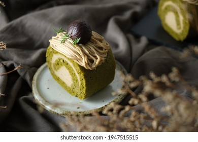 Green Tea Swiss Roll Cake With Chestnut Cream Filling Set On Cafe Table.