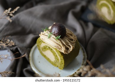 Green Tea Swiss Roll Cake With Chestnut Cream Filling Set On Cafe Table.