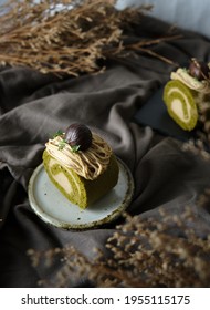 Green Tea Swiss Roll Cake With Chestnut Cream Filling Set On Cafe Table.