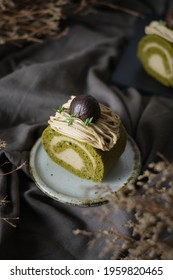 Green Tea Swiss Roll Cake With Chestnut Cream Filling Set On Cafe Table.