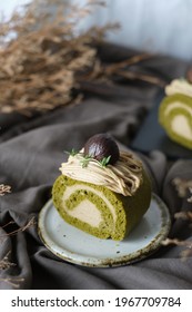 Green Tea Swiss Roll Cake With Chestnut Cream Filling Set On Cafe Table.