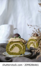 Green Tea Swiss Roll Cake With Chestnut Cream Filling Set On Cafe Table.