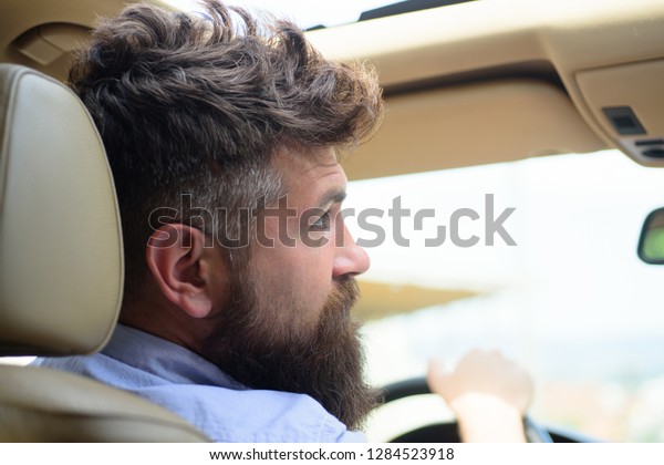 Green tech. Bearded man travel by automobile\
transport. Hipster enjoying road trip. Eco driving is an ecologic\
driving style. Eco friendly and sustainable travel. Travelling by\
road transport.