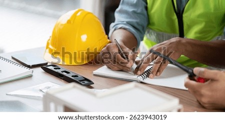 Green tech safety practices with engineers writing in notebook