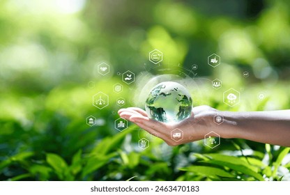 Green technology or Environmental technology to Sustainable development goal (SDGs) concept. Hands holding Global with Environment icon on a green background. Business Value Chain. Net zero concept. - Powered by Shutterstock