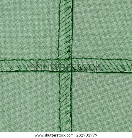 green textile texture with  inseams in shape of the cross