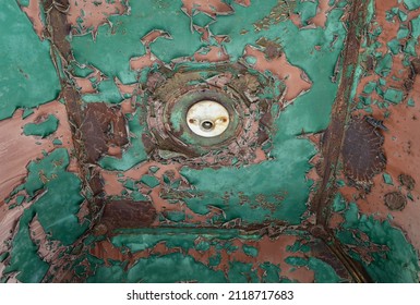 Green Textured Background. Based On A Closeup Photo Of The Ceiling Of An Antique Elevator. It Shows Peeling Green And Pink Paint And An Empty Light Socket.