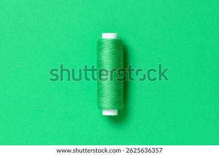 Green thread spool close-up flat lay top view with copy space for text